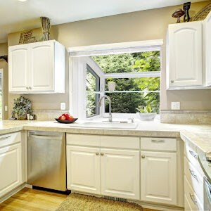White kitchen cabinets with steel appliances and light tone hardwood floor